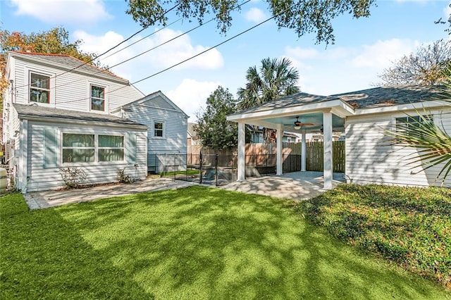 rear view of house featuring a yard, ceiling fan, and a patio area