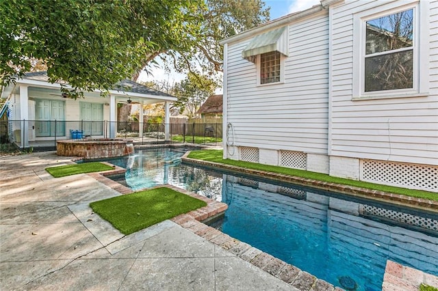 view of swimming pool with ceiling fan, a hot tub, and a patio