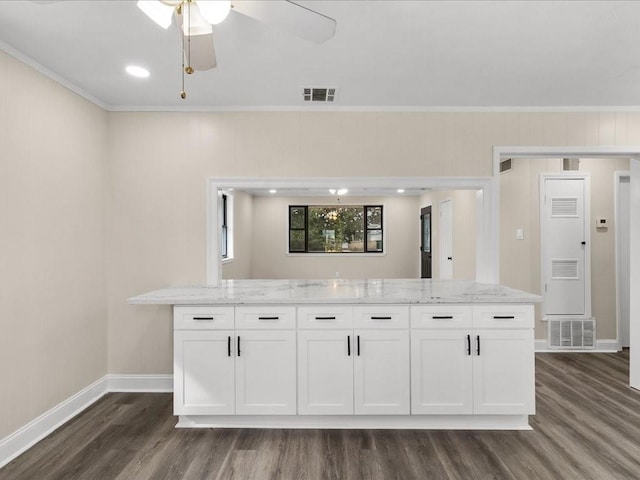 kitchen featuring white cabinetry, ornamental molding, and light stone countertops