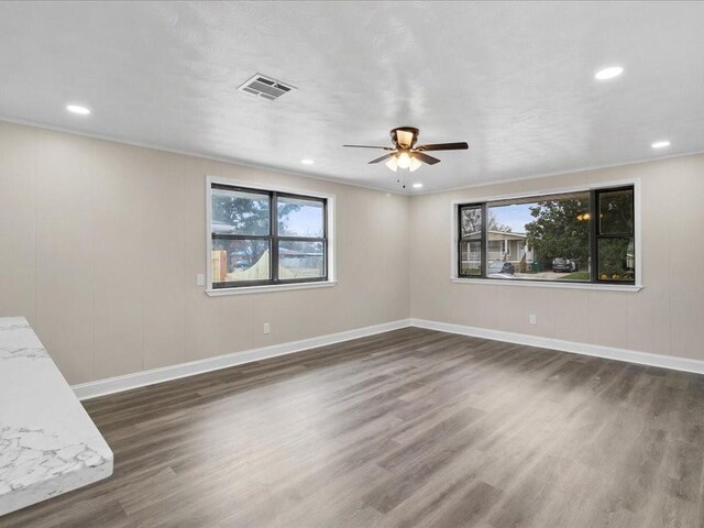 spare room featuring dark wood-type flooring, ornamental molding, and ceiling fan