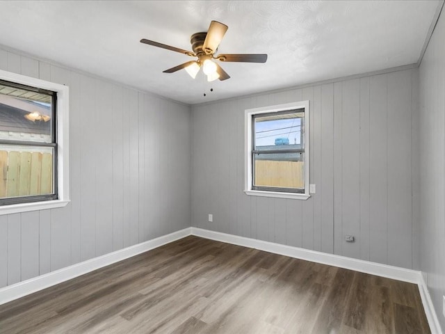 empty room with ceiling fan and dark hardwood / wood-style flooring