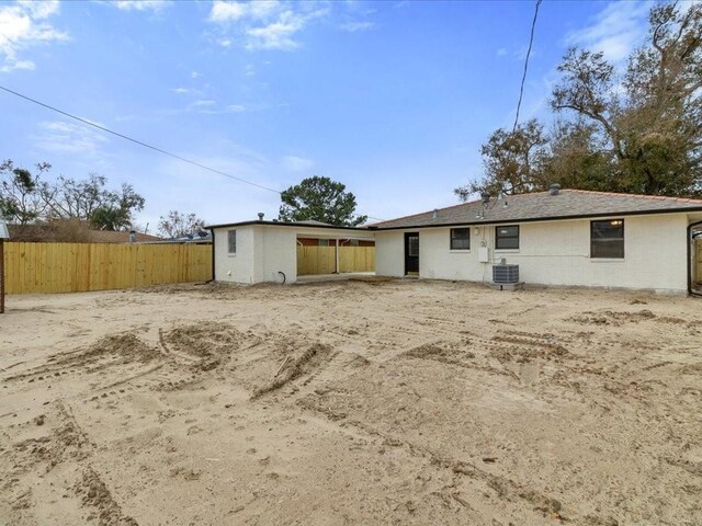 rear view of property featuring a yard and central air condition unit