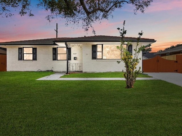 single story home featuring a lawn