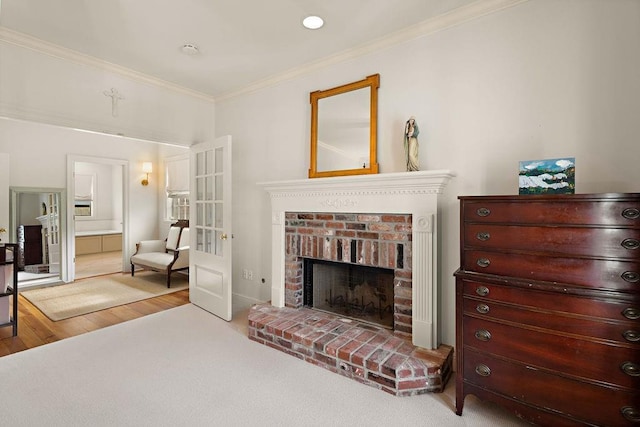 interior space with hardwood / wood-style flooring, ornamental molding, a brick fireplace, and a closet