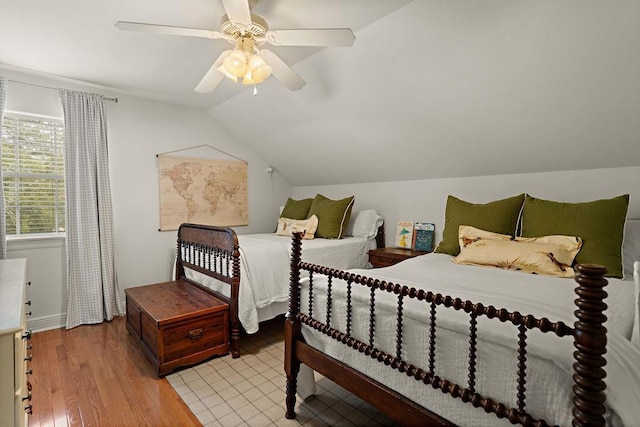 bedroom with ceiling fan, lofted ceiling, and light hardwood / wood-style flooring