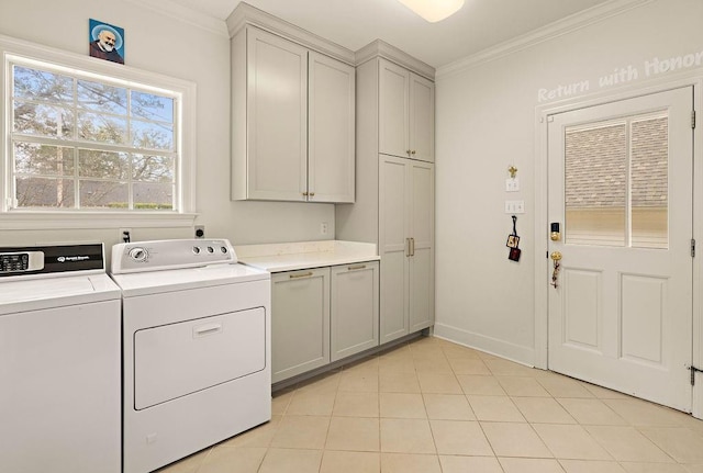 laundry room with light tile patterned floors, ornamental molding, cabinets, and washing machine and clothes dryer