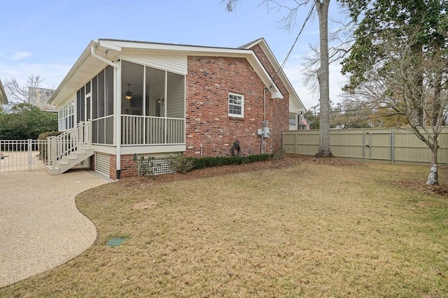 view of side of home with a sunroom and a yard