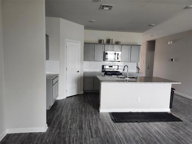 5574 Grand Springs Rd, Slidell, LA 70461 - kitchen featuring stainless steel appliances, gray cabinets, backsplash, dark wood-type flooring, and baseboards