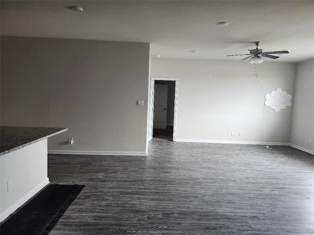 unfurnished living room featuring ceiling fan and dark hardwood / wood-style flooring