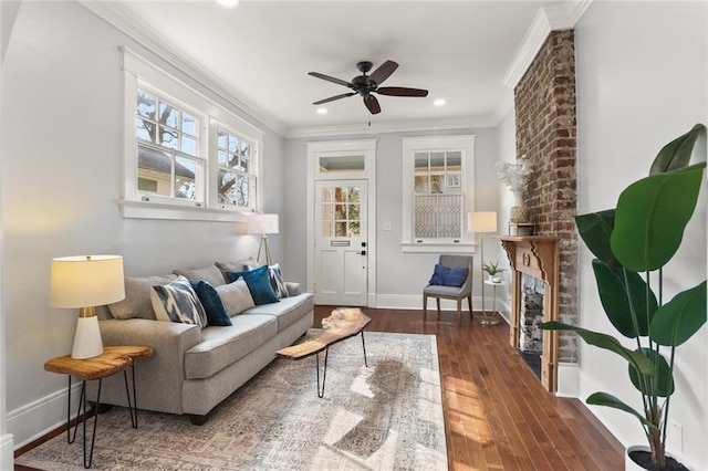 living room featuring crown molding, ceiling fan, dark hardwood / wood-style floors, and a brick fireplace