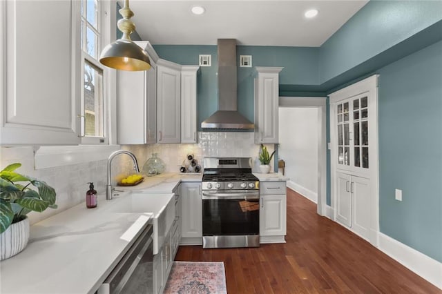 kitchen featuring stainless steel appliances, tasteful backsplash, white cabinets, and wall chimney exhaust hood