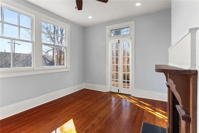 empty room featuring wood-type flooring, plenty of natural light, and ceiling fan