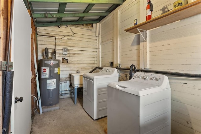 laundry room featuring washing machine and clothes dryer, wooden walls, and electric water heater