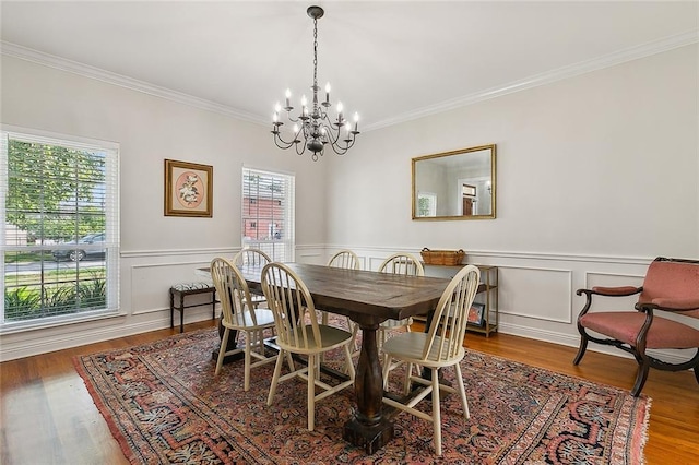 dining area with an inviting chandelier, hardwood / wood-style flooring, and ornamental molding