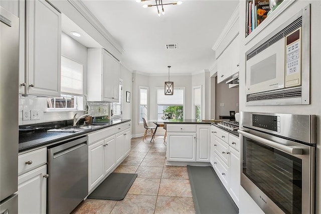 kitchen with white cabinetry, crown molding, tasteful backsplash, pendant lighting, and stainless steel appliances