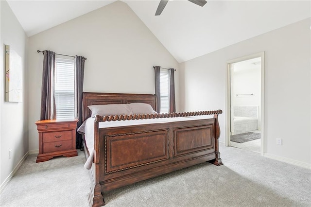 bedroom with high vaulted ceiling, connected bathroom, light colored carpet, and ceiling fan