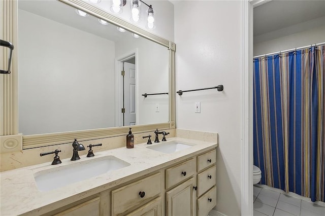 bathroom with tile patterned flooring, vanity, and toilet