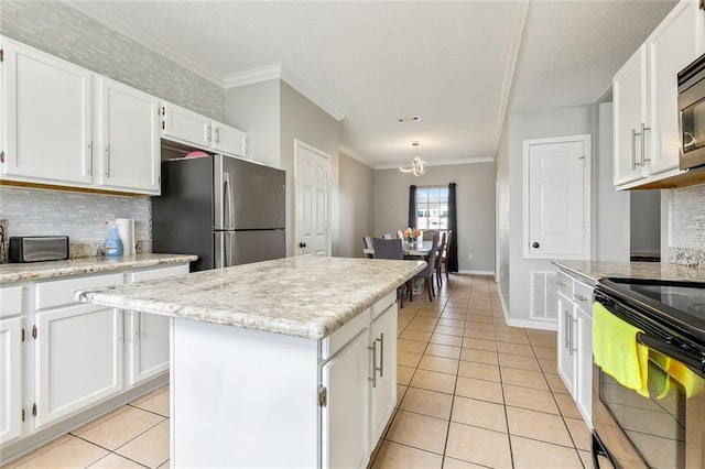 kitchen with stainless steel appliances, white cabinetry, a center island, and light tile patterned floors