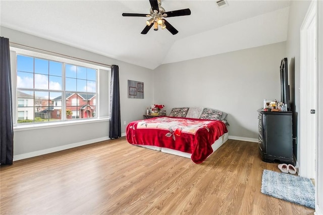 bedroom featuring hardwood / wood-style flooring, vaulted ceiling, and ceiling fan