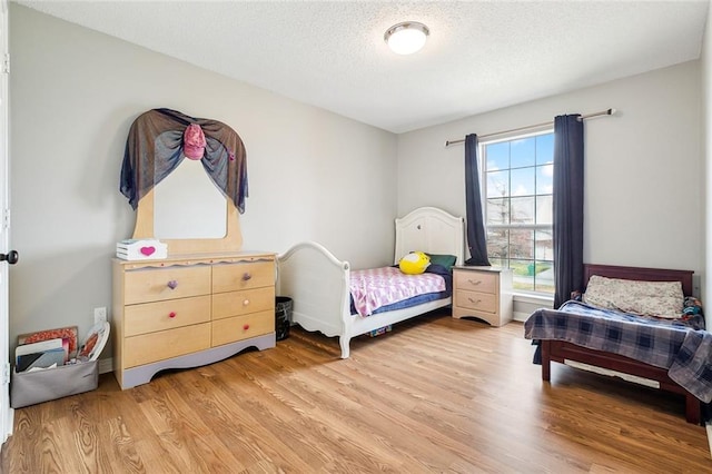 bedroom featuring hardwood / wood-style floors and a textured ceiling