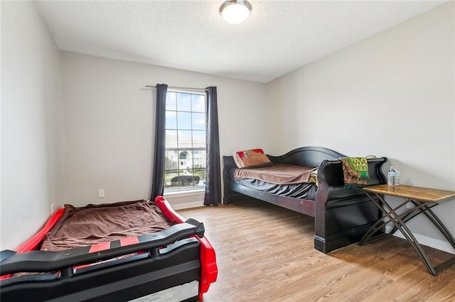 bedroom featuring light hardwood / wood-style flooring and a textured ceiling