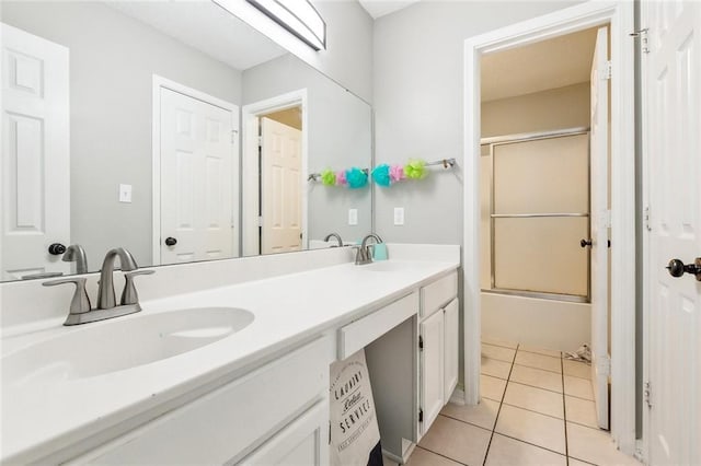 bathroom featuring enclosed tub / shower combo, tile patterned floors, and vanity