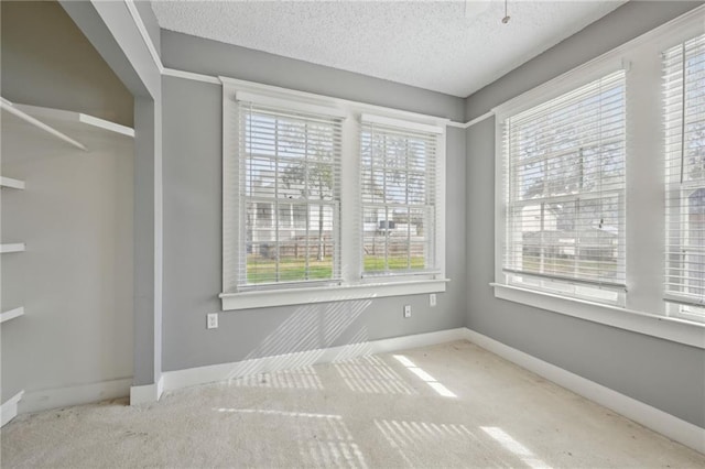 carpeted spare room featuring a textured ceiling