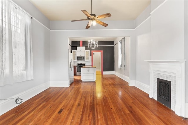 unfurnished living room with hardwood / wood-style flooring, ceiling fan with notable chandelier, and a tile fireplace