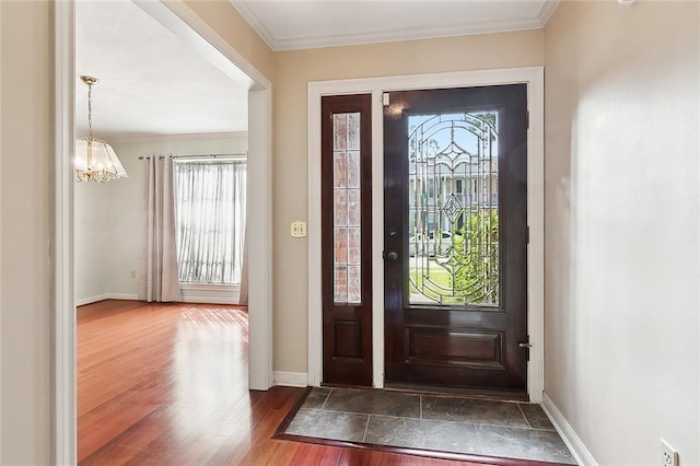 entrance foyer with crown molding, a notable chandelier, dark hardwood / wood-style flooring, and a wealth of natural light