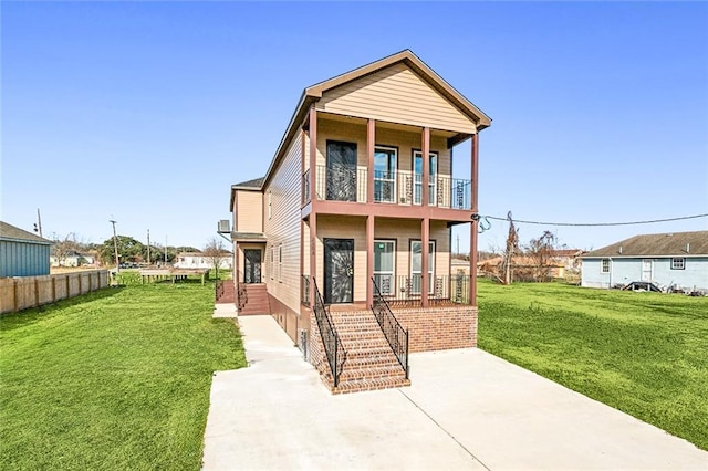 back of property with a balcony, covered porch, and a lawn