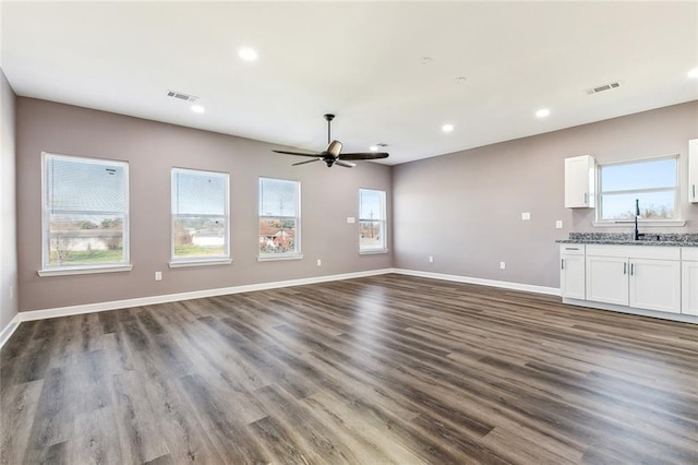 unfurnished living room with dark wood-type flooring, sink, and ceiling fan