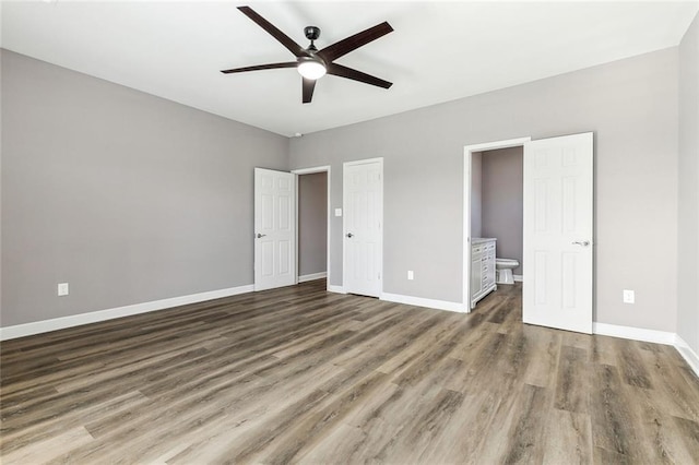 unfurnished bedroom with dark hardwood / wood-style floors, ceiling fan, and ensuite bathroom