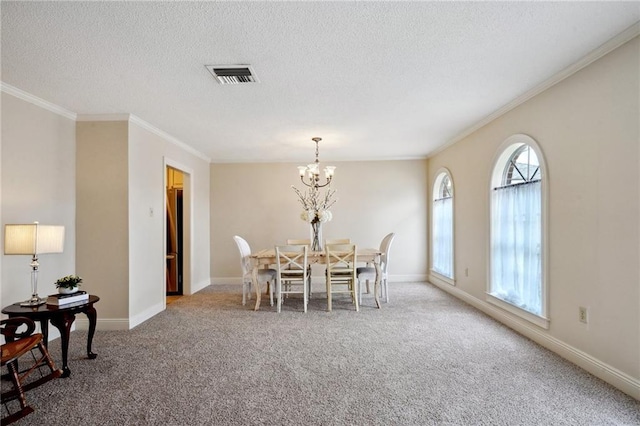 carpeted dining space featuring an inviting chandelier, ornamental molding, and a textured ceiling