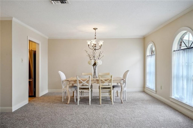 carpeted dining room with crown molding, a textured ceiling, and a chandelier