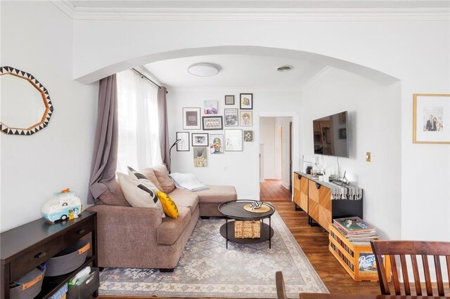 living room featuring ornamental molding and dark hardwood / wood-style floors