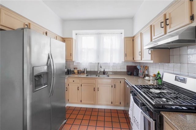 kitchen with sink, stainless steel appliances, tasteful backsplash, light stone counters, and light brown cabinets