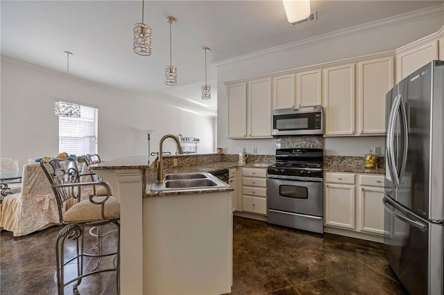 kitchen featuring hanging light fixtures, appliances with stainless steel finishes, sink, and a breakfast bar