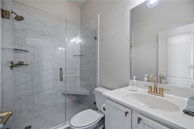 bathroom featuring vanity, a shower with shower door, and toilet