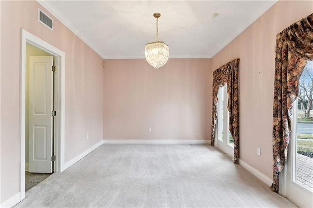 carpeted spare room with ornamental molding and a notable chandelier