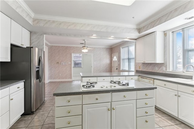 kitchen featuring white cabinetry, sink, white gas stovetop, and a center island