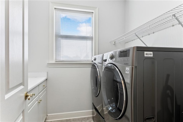 laundry room featuring cabinets and washer and dryer