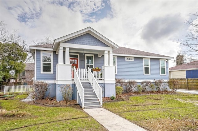 view of front of home featuring covered porch and a front lawn