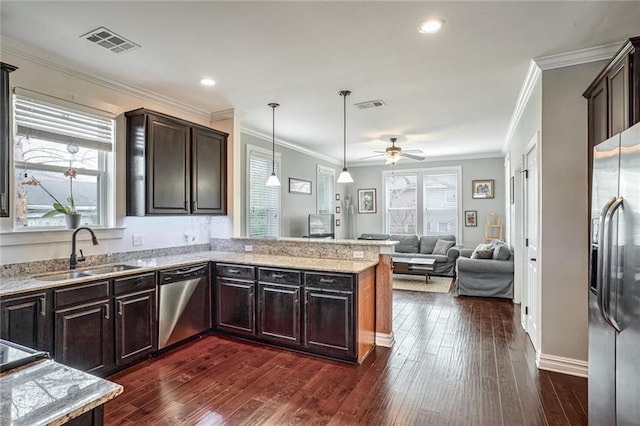 kitchen with dark brown cabinetry, sink, hanging light fixtures, appliances with stainless steel finishes, and dark hardwood / wood-style floors