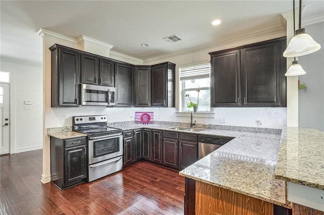 kitchen featuring stainless steel appliances, light stone countertops, hanging light fixtures, and sink