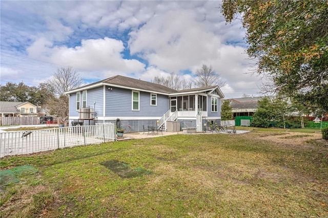 rear view of property with a lawn and a sunroom