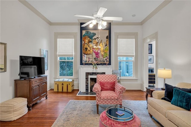 living room featuring a tiled fireplace, crown molding, and plenty of natural light