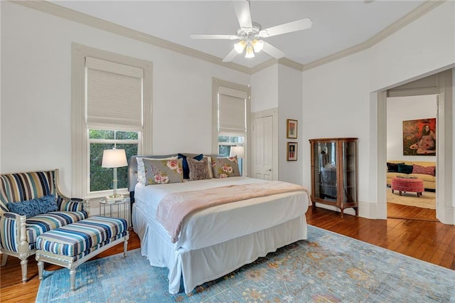 bedroom with crown molding, ceiling fan, and wood-type flooring