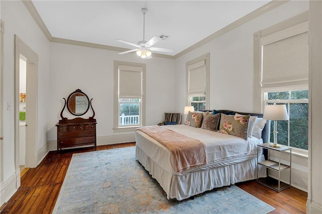 bedroom with dark hardwood / wood-style flooring, multiple windows, and ornamental molding