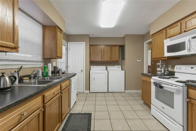 kitchen with washing machine and dryer, sink, light tile patterned flooring, and white appliances