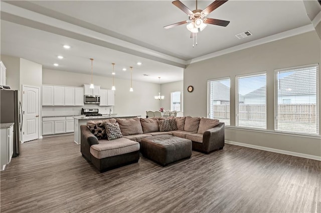 living room featuring dark hardwood / wood-style floors and ceiling fan with notable chandelier